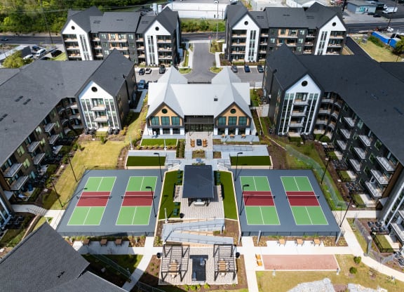 an aerial view of a building with tennis courts