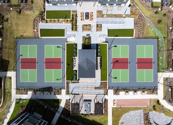 an aerial view of several tennis courts on a city