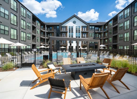 an outdoor patio area with a fire pit and chairs