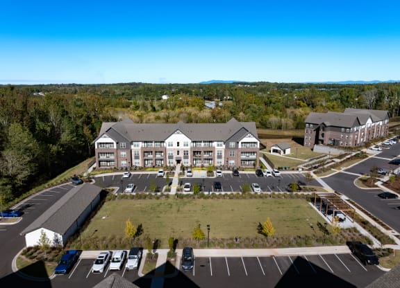 an aerial view of an apartment building and parking lot