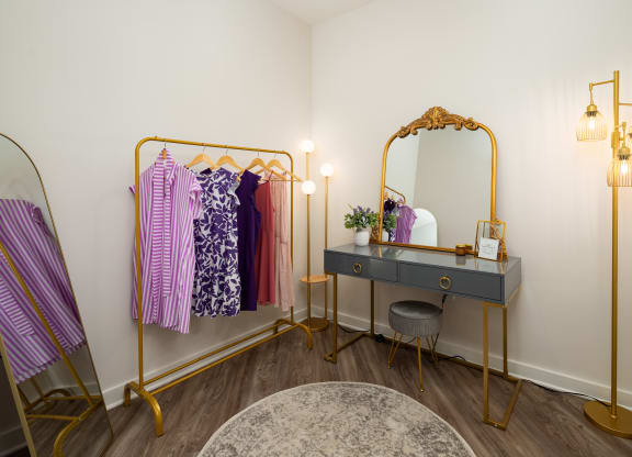 a dressing room with a black desk and a vanity with a mirror