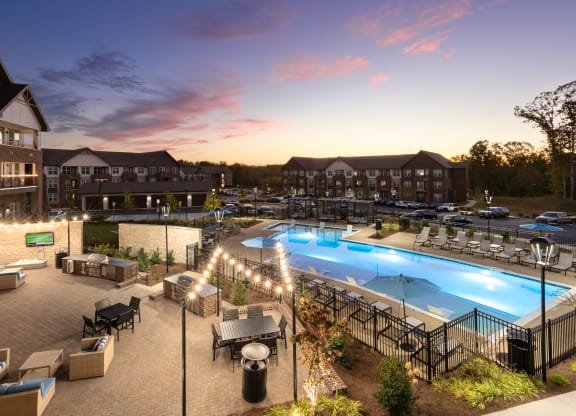 an aerial view of a resort pool at dusk