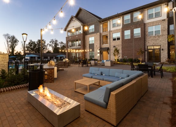 an outdoor patio with couches and tables and a fire pit
