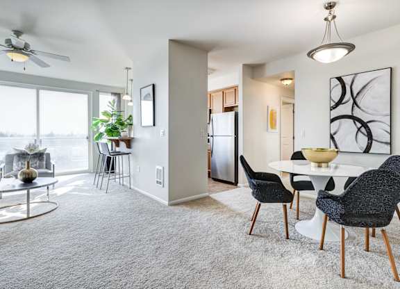 a living and dining area with a white table and black and white chairs