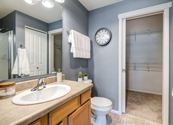 a bathroom with a toilet sink mirror and shower