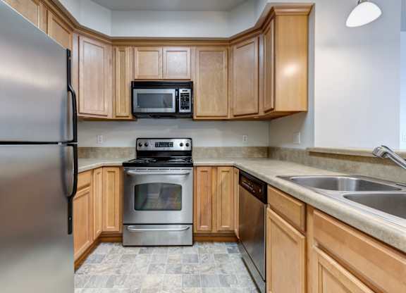 a kitchen with wooden cabinets and stainless steel appliances