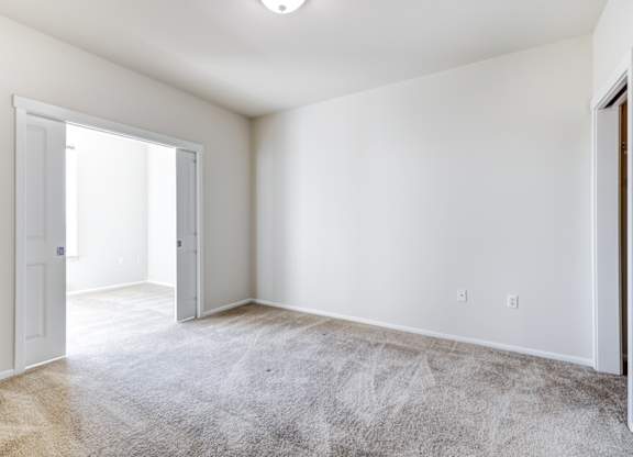 a bedroom with white walls and carpet