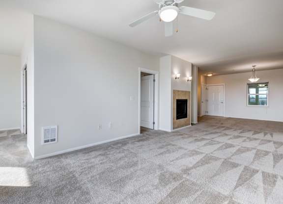 a living room with a fireplace and a ceiling fan