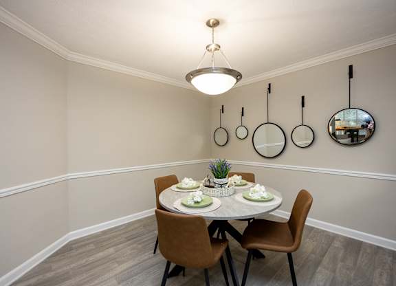 A dining room with a round table set for two.