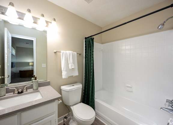 A bathroom with a toilet, sink, and bathtub.