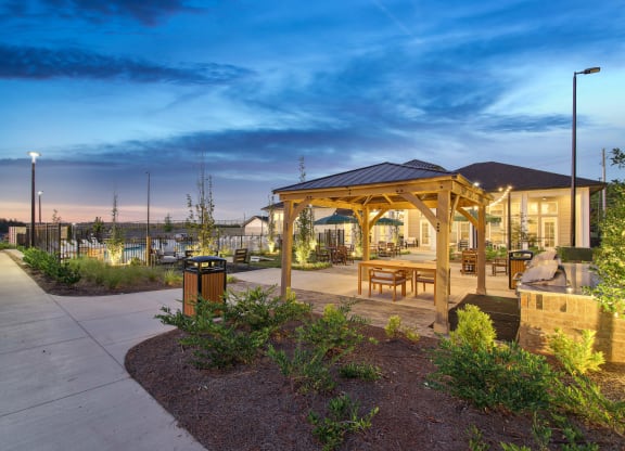 a pavilion with benches and a picnic table at dusk