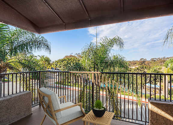A balcony with a chair and a potted plant.