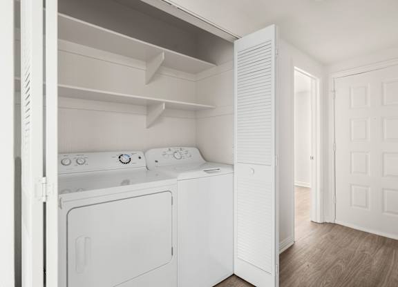 A white washing machine and dryer in a small laundry room.
