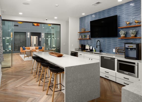 a kitchen with a large island and a counter top with chairs