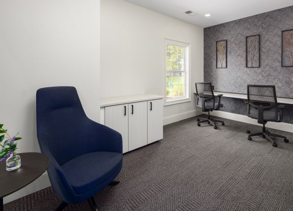 an office with two chairs and a desk and a window