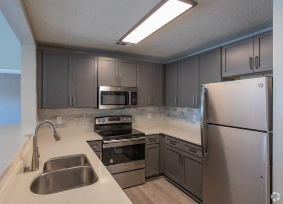 a kitchen with stainless steel appliances and white counter tops
