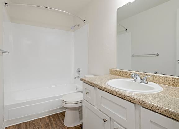 A white bathroom with a toilet, sink, and bathtub.