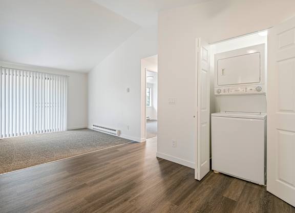 A kitchen with white appliances and wooden floors.