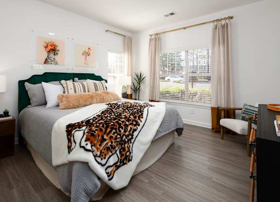a bedroom with a bed with a leopard blanket