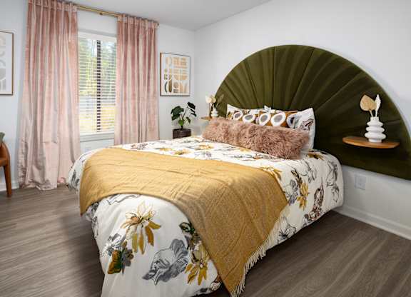 a bedroom with a bed with a green headboard