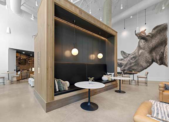 A modern living room with a large wolf head on the wall.