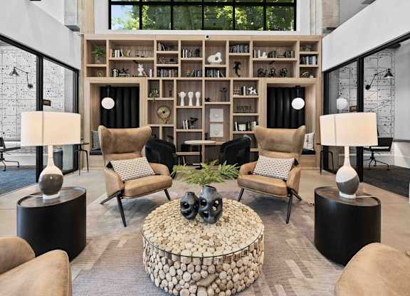 A living room with a stone coffee table and a bookshelf filled with books.