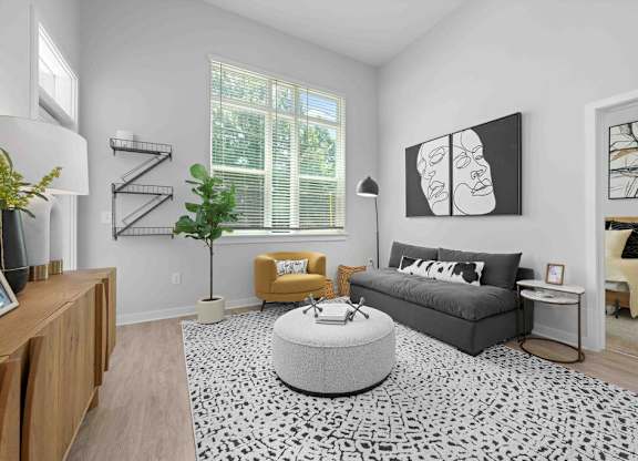 A living room with a grey sofa, yellow armchair, and a black and white patterned rug.
