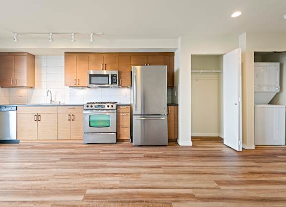 A kitchen with wooden floors and stainless steel appliances.