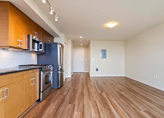 A kitchen with wooden floors and a blue refrigerator.