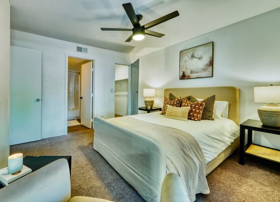 a bedroom with a large bed and a ceiling fan