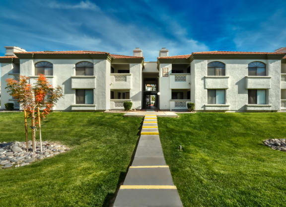 a large white building with a sidewalk in front of it