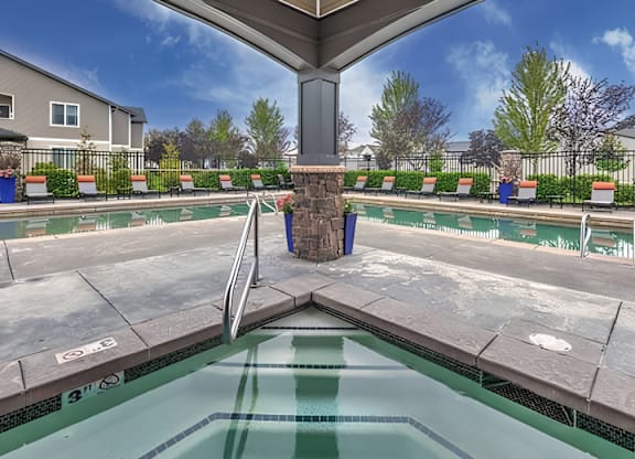 A pool with a diving board and a fence around it.