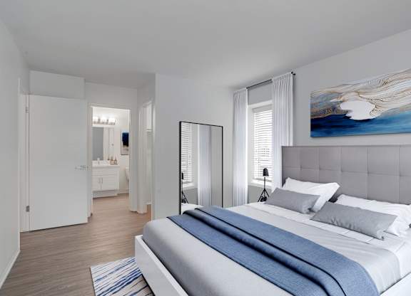 A bedroom with a large bed and a painting on the wall.