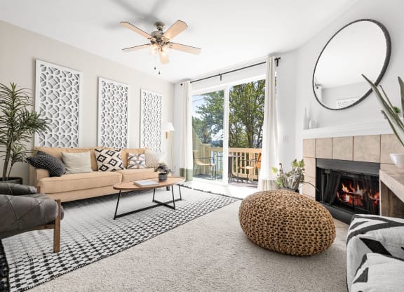 a living room with white walls and a sliding glass door leading to a balcony