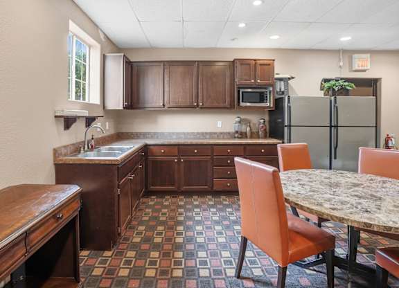 A kitchen with a table and chairs.