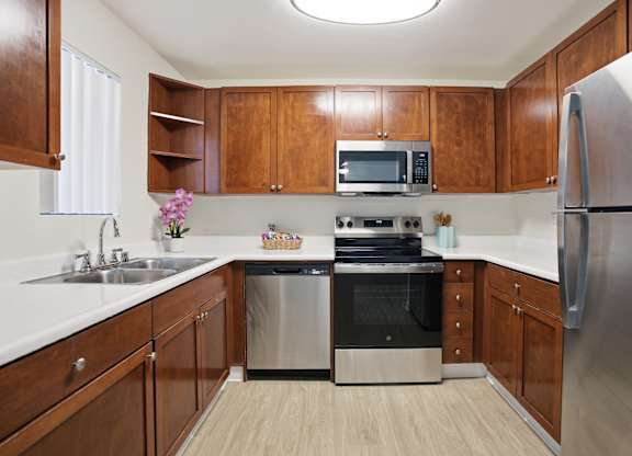 A kitchen with wooden cabinets and stainless steel appliances.