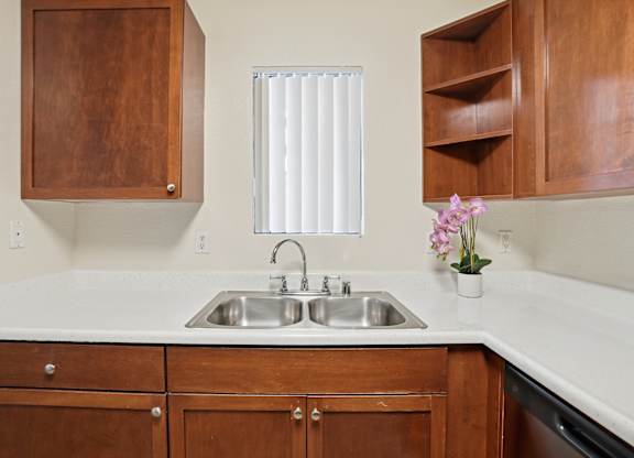 A kitchen with a sink and wooden cabinets.
