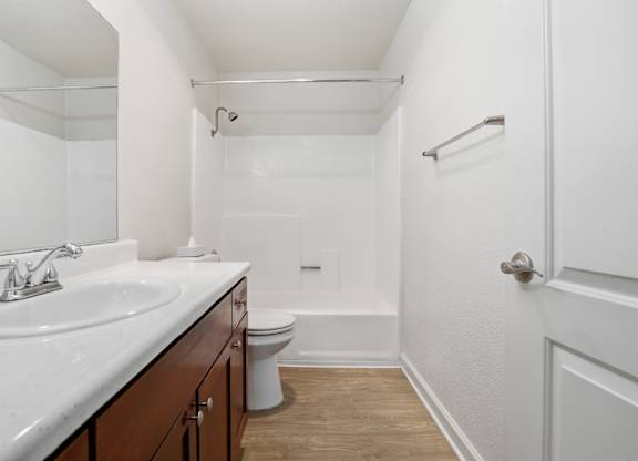 A white bathroom with a toilet, sink, and bathtub.