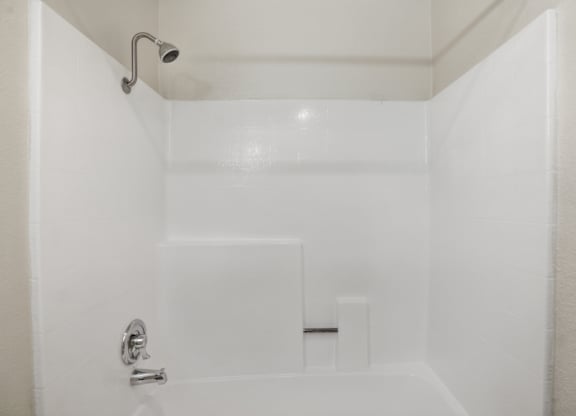 A white bathroom with a shower and a door.
