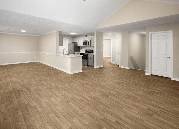 Empty living room with plank-style wood floors.