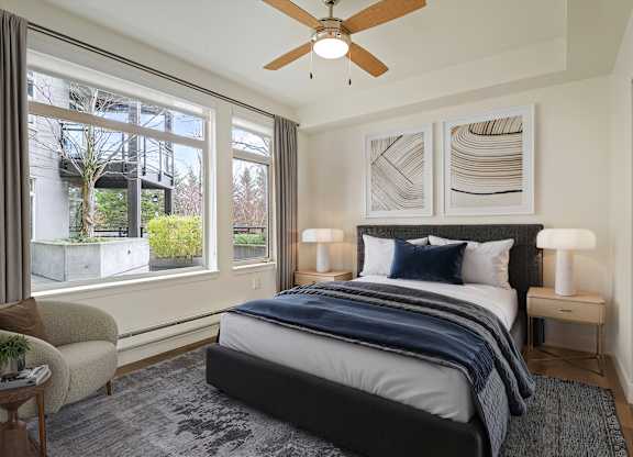 A bedroom with a large bed and a ceiling fan.