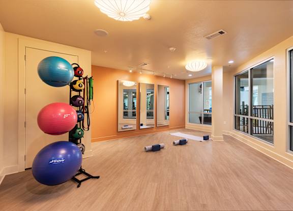 A room with exercise equipment and mirrors on the wall.