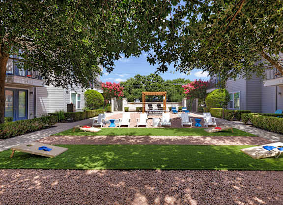 A playground area with a slide and swings in a residential area.