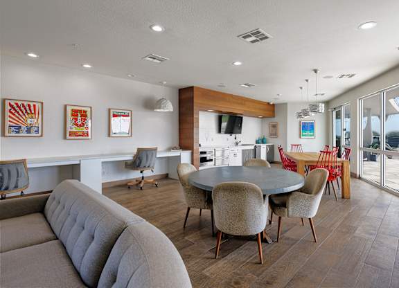 A modern living room with a grey sofa and a round table with chairs.