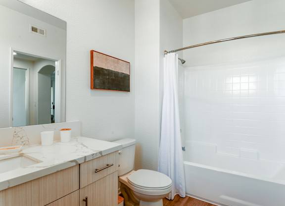 A bathroom with a toilet, sink, and shower.