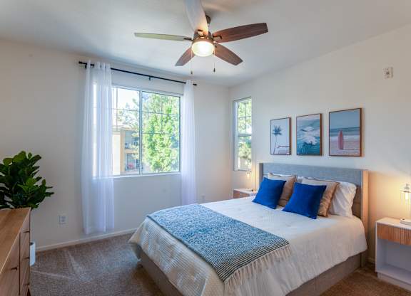 A bedroom with a large bed and a ceiling fan.