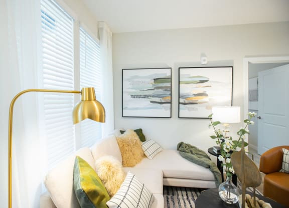 a living room with a couch and two pictures on the wall