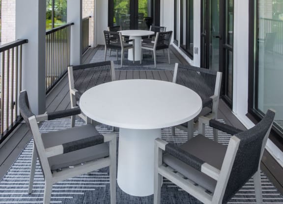 a covered porch with a white table and chairs