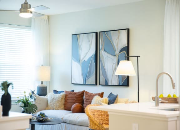 a living room with a couch and two paintings on the wall