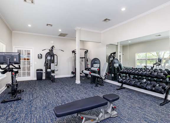 a gym with cardio equipment and exercise machines at Clear Creek Meadows Apartments, Texas